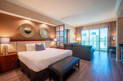 a hotel room with a bed and a couch at No Resort Fee Strip View Balcony+ Free Valet+Pool in Las Vegas