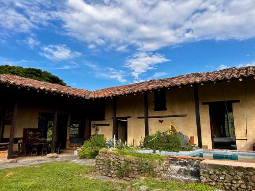 a house with a pool in front of it at Cabañas en la montaña Viga Vieja in San Peregrino