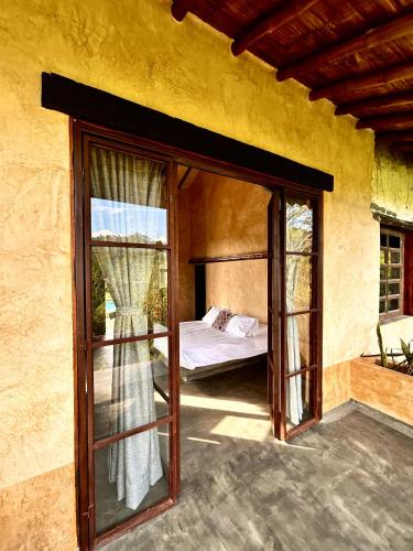 a room with a bed and a glass door at Cabañas en la montaña Viga Vieja in San Peregrino