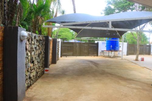 a patio with a fence and a blue umbrella at Musina Crown Guest House in Musina