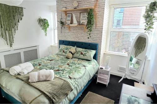 Un dormitorio con una cama grande con cabecero azul. en The Hideaway Cottage Feel Patio Central Parking, en Southport
