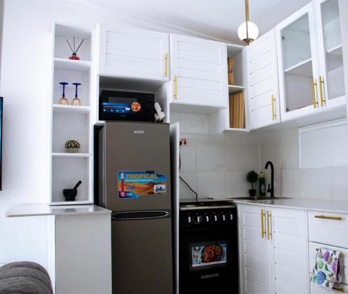 a kitchen with a refrigerator and white cabinets at Luxe cozy home in Dar es Salaam