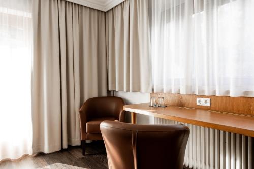 a room with a desk and a chair and a window at Hotel Maria Theresia in Mayrhofen