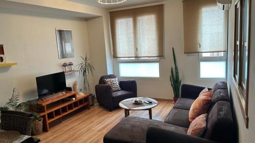 a living room with a couch and a tv at MÍ casa YOUR HOME in Valencia