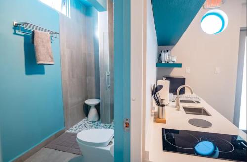 a blue and white bathroom with a toilet and a sink at Aquabella 4 Island Serenity in Isla Verde in San Juan