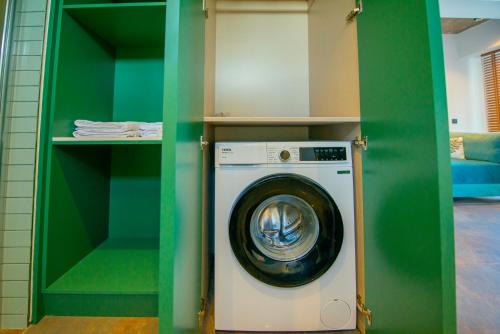 a laundry room with a washing machine in a green wall at Nakas Hotel in Fethiye