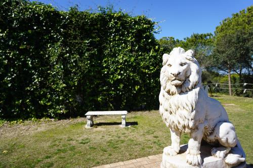 a statue of a lion sitting next to a bench at Complejo Turístico Rural Nazaret De Moguer in Moguer