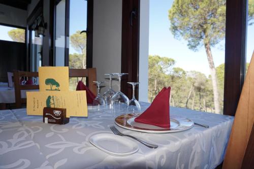 a table with a red hat and plates on it at Complejo Turístico Rural Nazaret De Moguer in Moguer