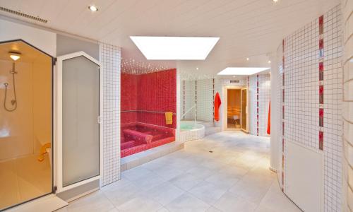 a bathroom with a red shower and a tub at Residenz Ambassador A32 in Leukerbad