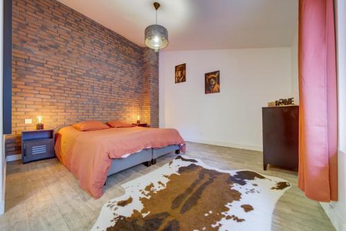 une chambre avec un lit et un mur de briques dans l'établissement Maison duplex, à Talange