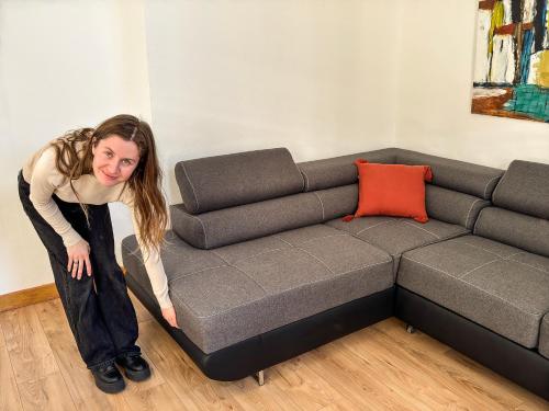 une femme est debout à côté d'un canapé dans l'établissement Place de la Mairie, Art Apparts, à Béziers