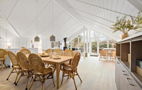a kitchen and dining room with a table and chairs at Stunning Home In Dronningmølle in Dronningmølle