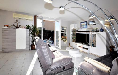 un salon avec deux chaises et une télévision dans l'établissement Nice Home In Lézignan-Corbières, à Lézignan-Corbières