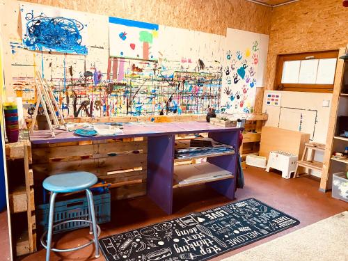 a painting room with a desk and a stool at Birkenhof, Haus Märli in Herisau