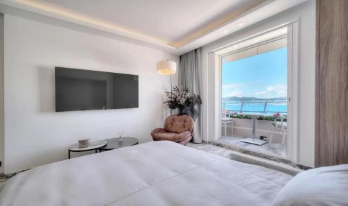 une chambre avec un grand lit et une grande fenêtre dans l'établissement Cannes 1 bedroom apartment - M6, à Cannes