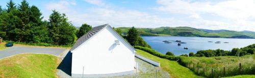 a small white tent on the side of a lake at Shorefield in Port na Long
