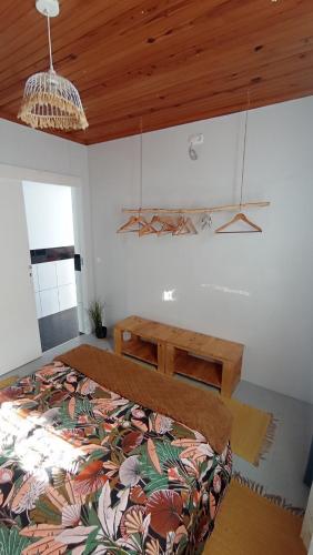 a bedroom with a bed and a wooden ceiling at Kanela Guest House in Machico
