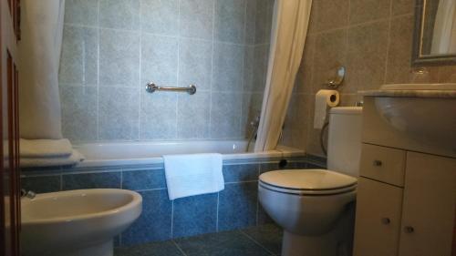 La salle de bains est pourvue de toilettes, d'une baignoire et d'un lavabo. dans l'établissement Hotel Luz de Guadiana, à Ayamonte