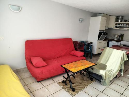 - un canapé rouge dans le salon avec une table dans l'établissement Résidence Sda F2-merlette - deux pièces 6 pers au soleil des alpes expo SUD-OUEST MAE-5751, à Orcières