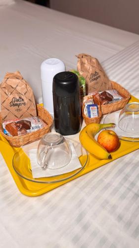 a tray with food and fruit on a table at Oasis Motel in Piracicaba