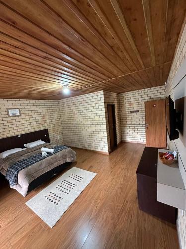 a bedroom with a bed and a wooden ceiling at Pousada Rural Encanto do Riacho in Bom Jardim da Serra