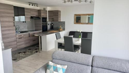 a kitchen and living room with a couch and a table at Sea view - Vue mer - Proche commerces - Nausicaa in Wimereux