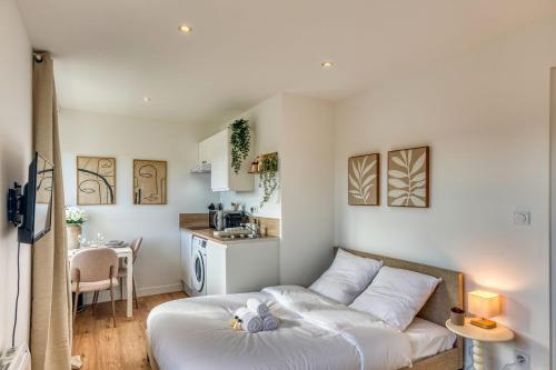 a living room with a bed and a kitchen at La Suite Crème - Métro D - Gare de Vénissieux in Vénissieux