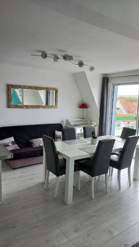 une salle à manger avec une table et des chaises blanches dans l'établissement Sea view - Vue mer - Proche commerces - Nausicaa, à Wimereux