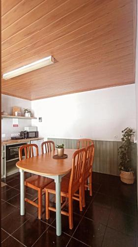 a kitchen with a table and chairs in a kitchen at Kanela Guest House in Machico