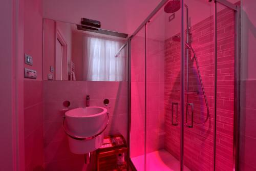 a pink bathroom with a sink and a shower at La Corte sul Naviglio in Boffalora sopra Ticino