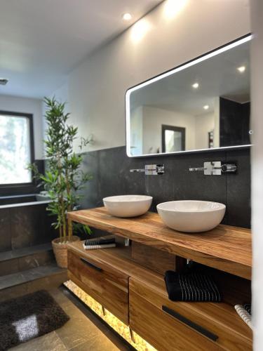 La salle de bains est pourvue de 2 lavabos sur un comptoir en bois avec un miroir. dans l'établissement Villa Bellysouh, à Sanary-sur-Mer