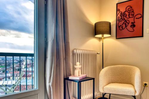 un salon avec une chaise et une fenêtre dans l'établissement Le Panoramique - Grand T2 métro B Oullins, à Oullins