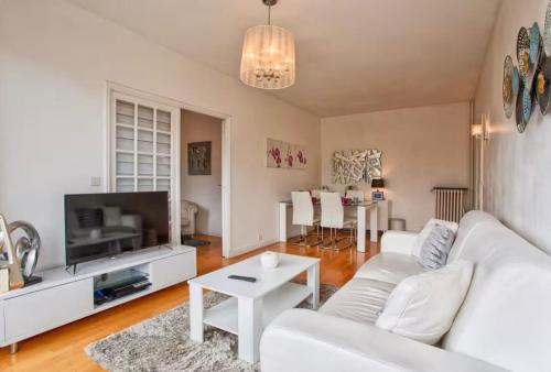 un salon avec un canapé blanc et une télévision dans l'établissement Urban Lodge YourHostHelper, à Deauville