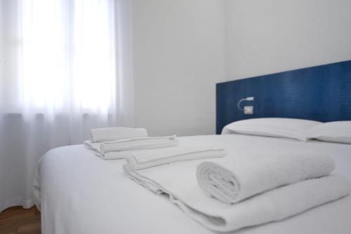 a white bed with white towels on top of it at La Corte sul Naviglio in Boffalora sopra Ticino