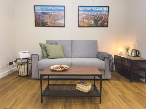a living room with a couch and a table at Dimora Aimonetto in Pinerolo
