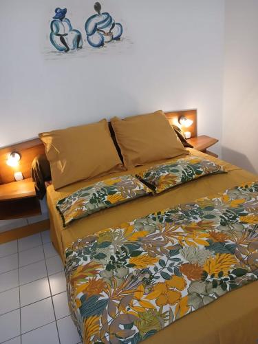 a bedroom with a bed with a colorful blanket at Le Bunga'Zen in Grand-Bourg