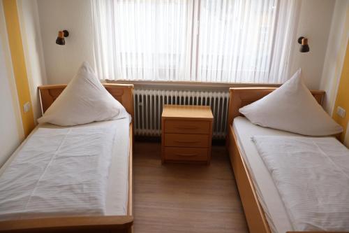 two beds in a small room with a window at Weinhaus Hirschen Bruttig in Bruttig-Fankel