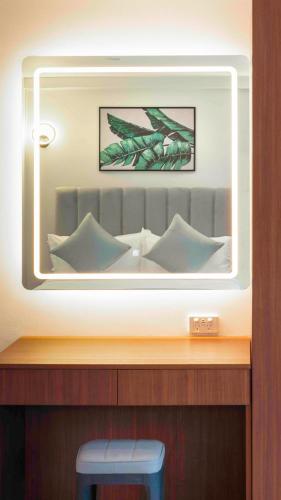 a mirror above a wooden table with a blue stool at Hibiscus Suites And Residences in Nadi