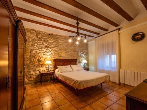 ein Schlafzimmer mit einem Bett und einer Steinwand in der Unterkunft Premium cottage with swimming pool in Hoya-Gonzalo