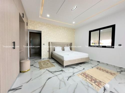 a bedroom with a bed and a marble floor at Villa Radisson Vu de mer 2 in Mezraya