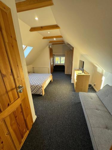 a attic room with two beds and a television at Chata Cerovo in Cerovo