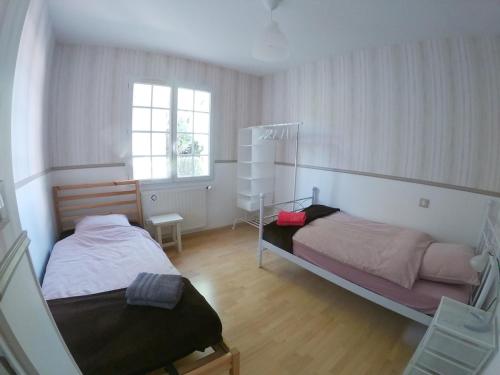 une chambre avec deux lits et une fenêtre dans l'établissement Maison avec grand jardin, à Saint-Martial-sur-Né