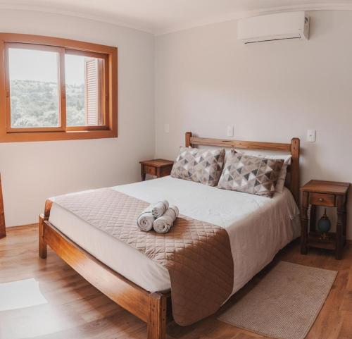 a bedroom with a large bed with two pillows at Casa, sítio, aconchegante no Vale dos Vinhedos. in Bento Gonçalves