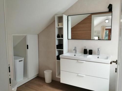 a white bathroom with a sink and a mirror at House Mande & Kate in Vrgorac