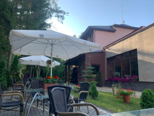 an outdoor table and chairs with an umbrella at Laguna Resort SPA in Augustów