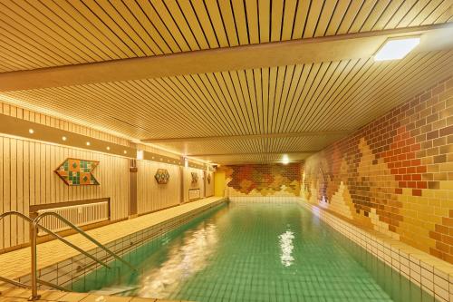 a swimming pool in a building with a brick wall at Bärbel, im Schwarzwald-Stil in Baiersbronn