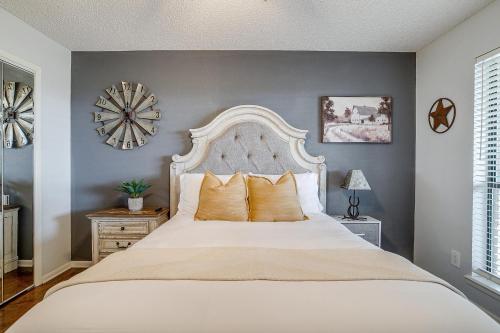 a bedroom with a large bed and a clock on the wall at Pool On The Golf Course With 3BR and Close to Tarleton in Stephenville