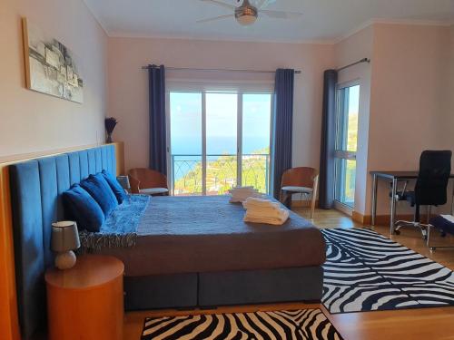 une chambre avec un lit et une grande fenêtre dans l'établissement Villa Palmera Sea View, à Arco da Calheta
