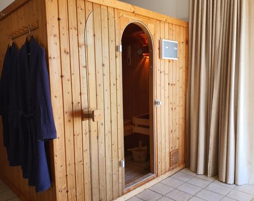 - une cabine de douche en bois avec une porte ouverte dans la salle de bains dans l'établissement Villa Palmera Sea View, à Arco da Calheta