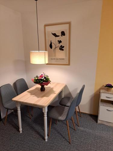 a table with chairs and a vase of flowers on it at Ferienhaus Willingen Diemelsee in Diemelsee
